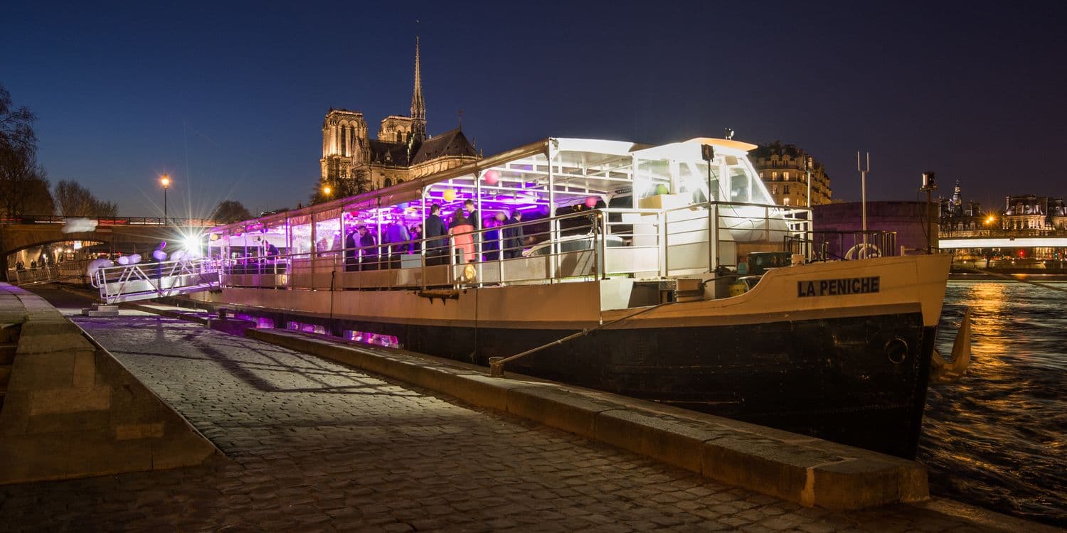 La Péniche, vue extérieure de nuit, lumière magenta sur la coque blanche