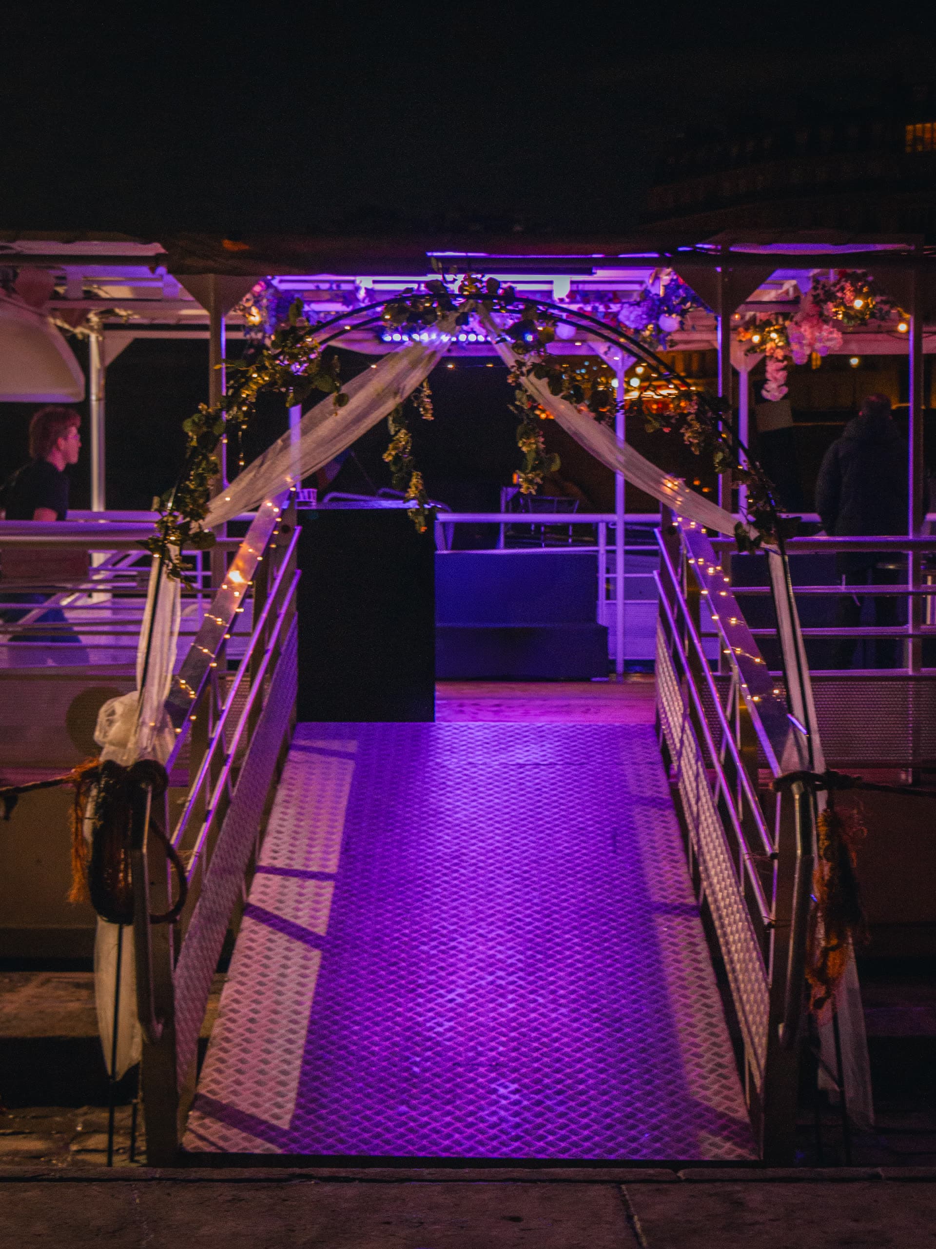 Ambiance soirée à bord de la péniche, lumières chaudes et invités